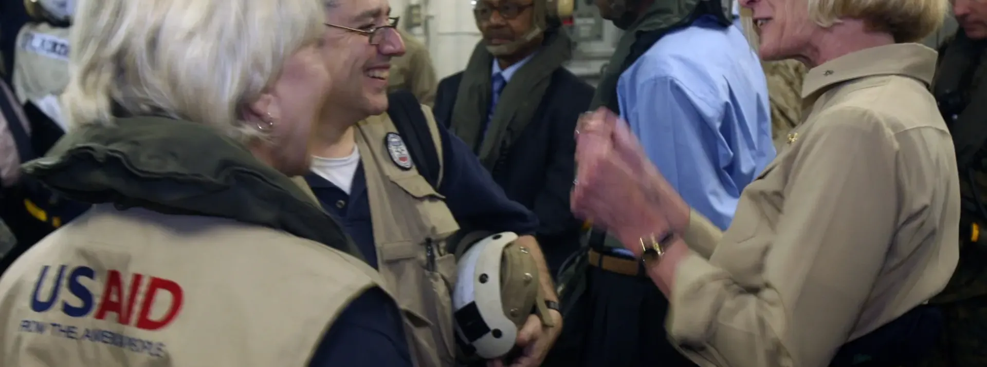 photo of a group of people looking at one another and in conversation and smiling 