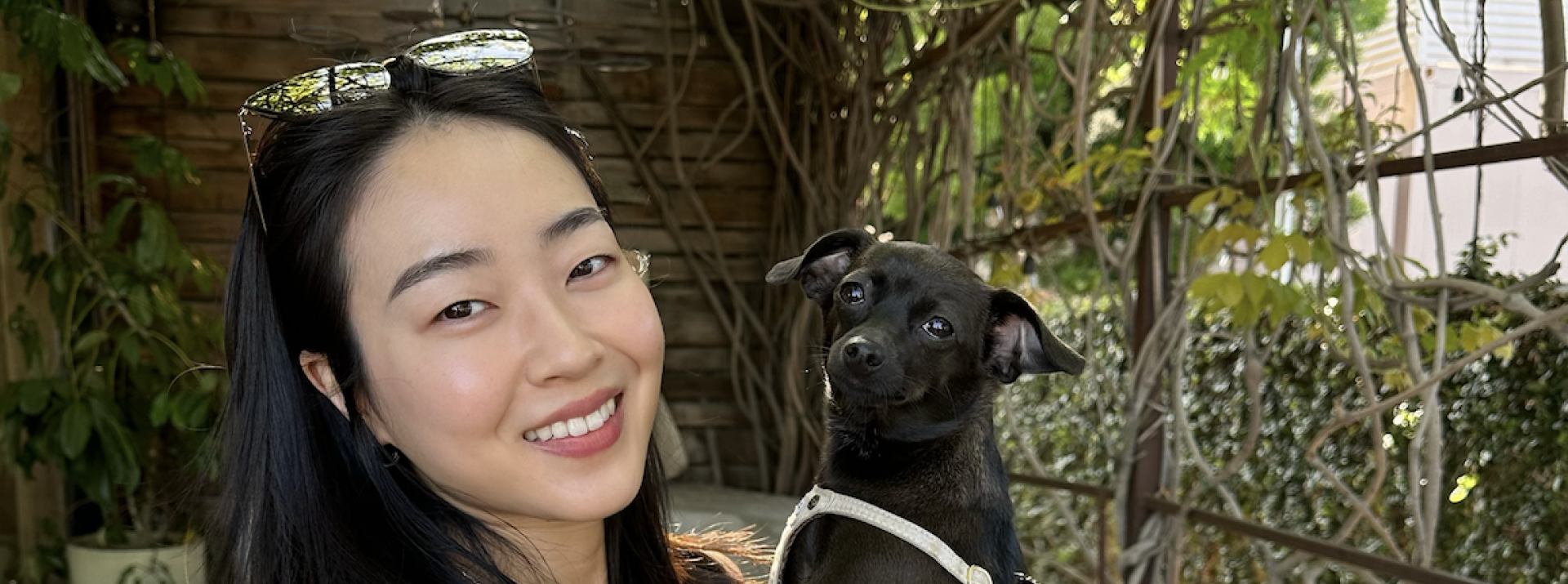 Woman smiling, holding dog.