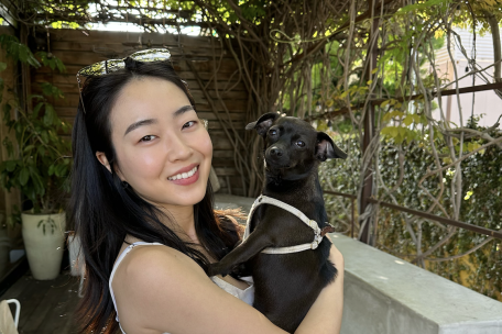 Woman smiling, holding dog.