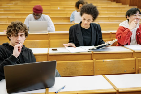 Five students in a lecture hall taking an exam.