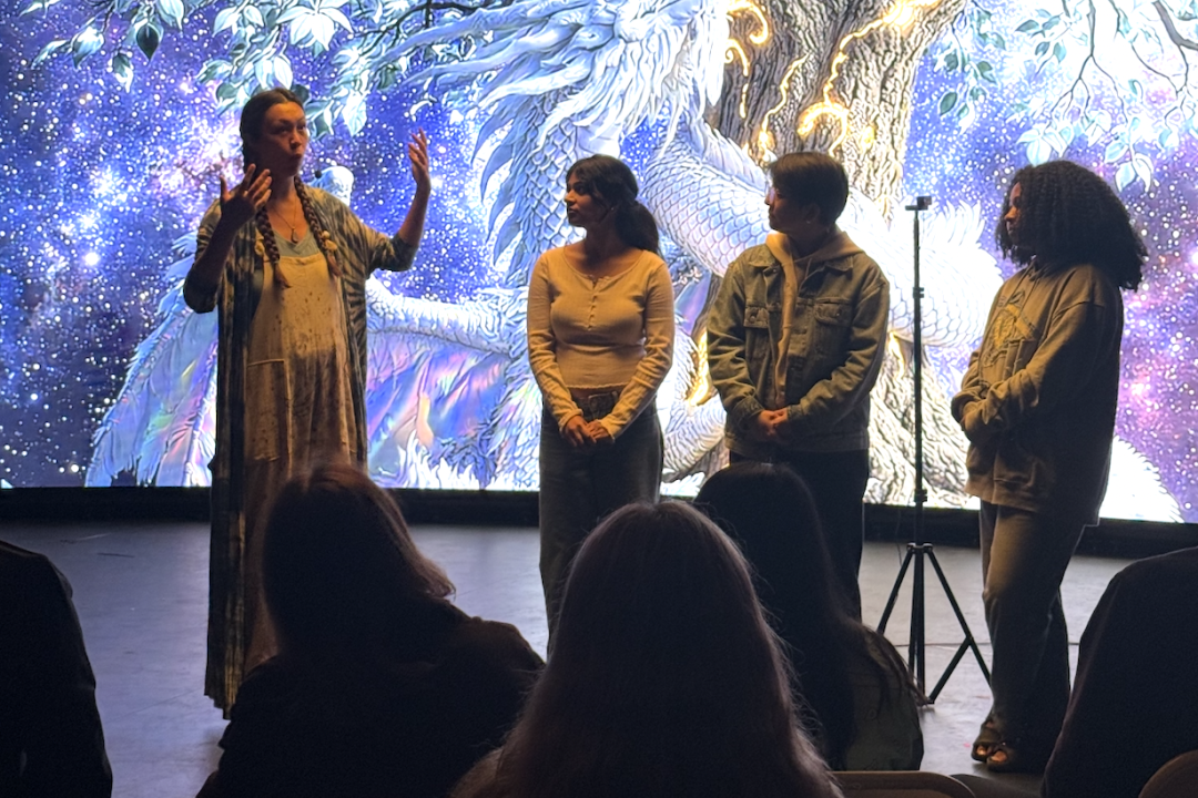 Four students presenting in front a purple cloud like generated image