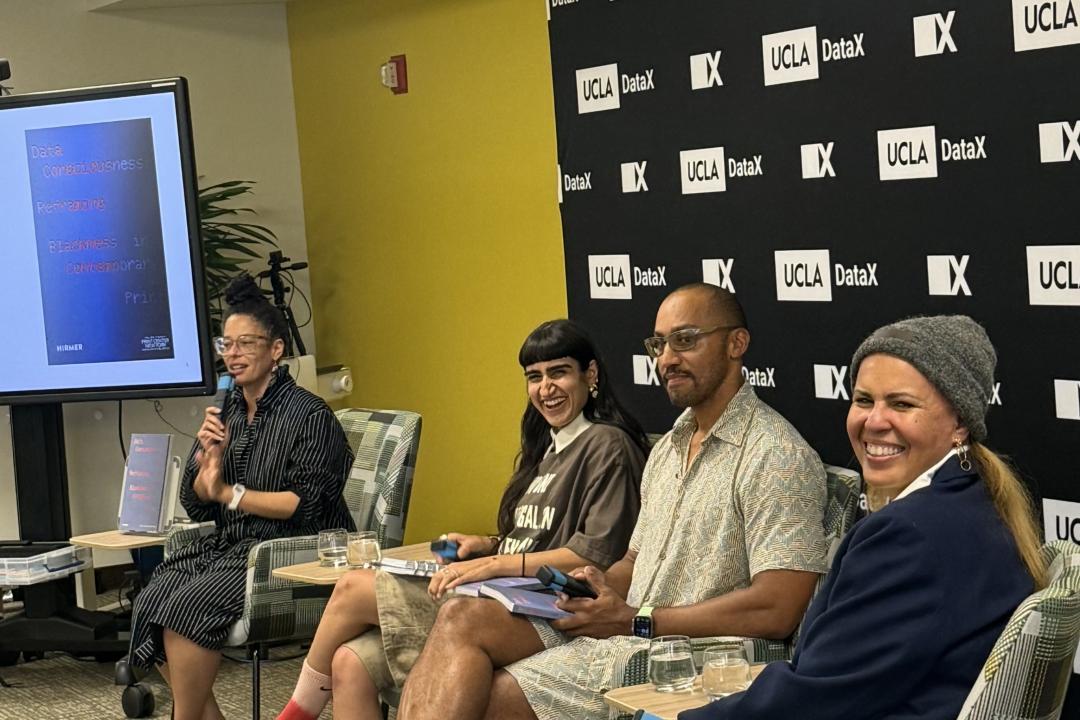 Panel conversation of four panelists; smiling.
